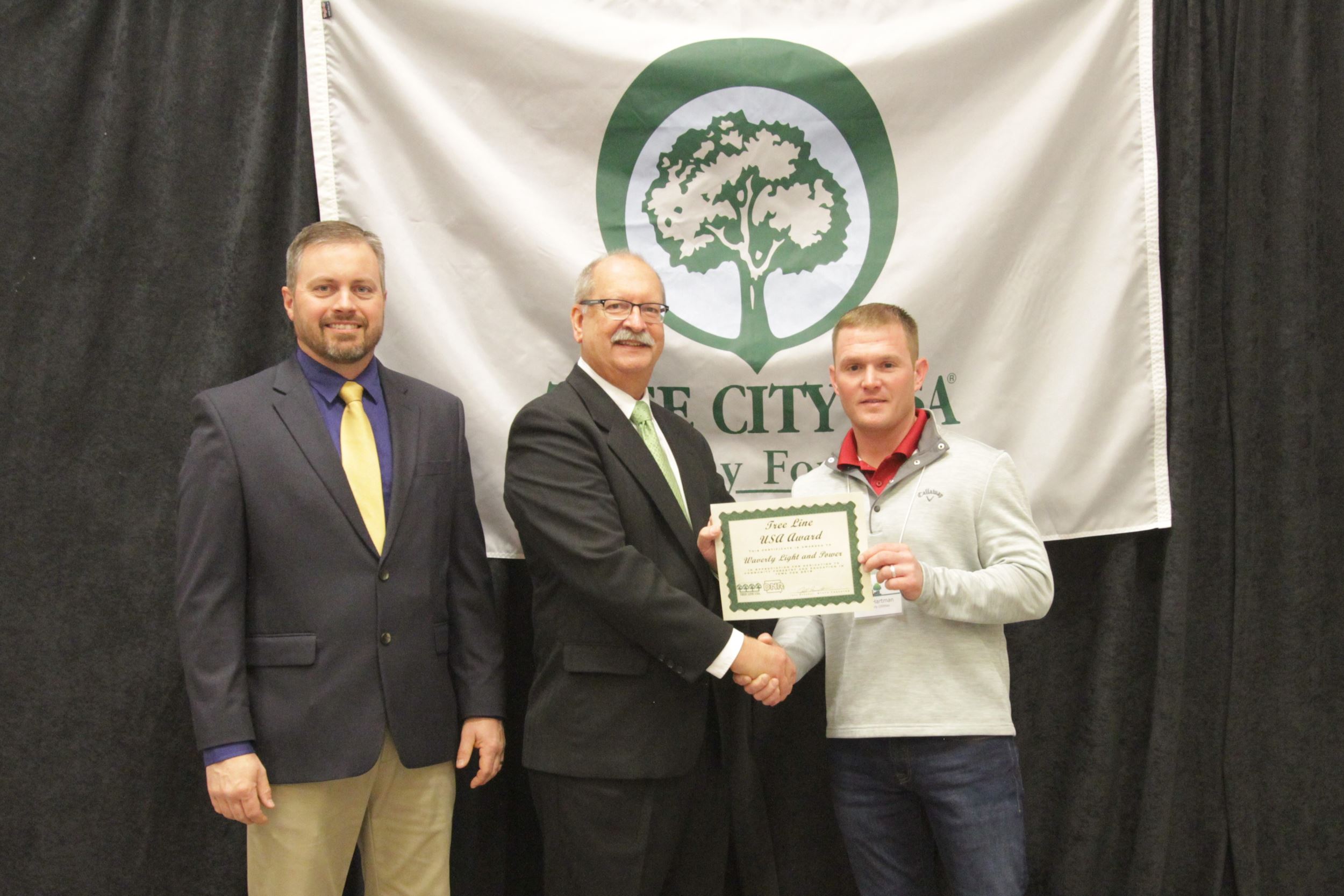 Ben Hartman, WU journey lineman, receiving the Tree Line USA award on behalf of Waverly Utilities.